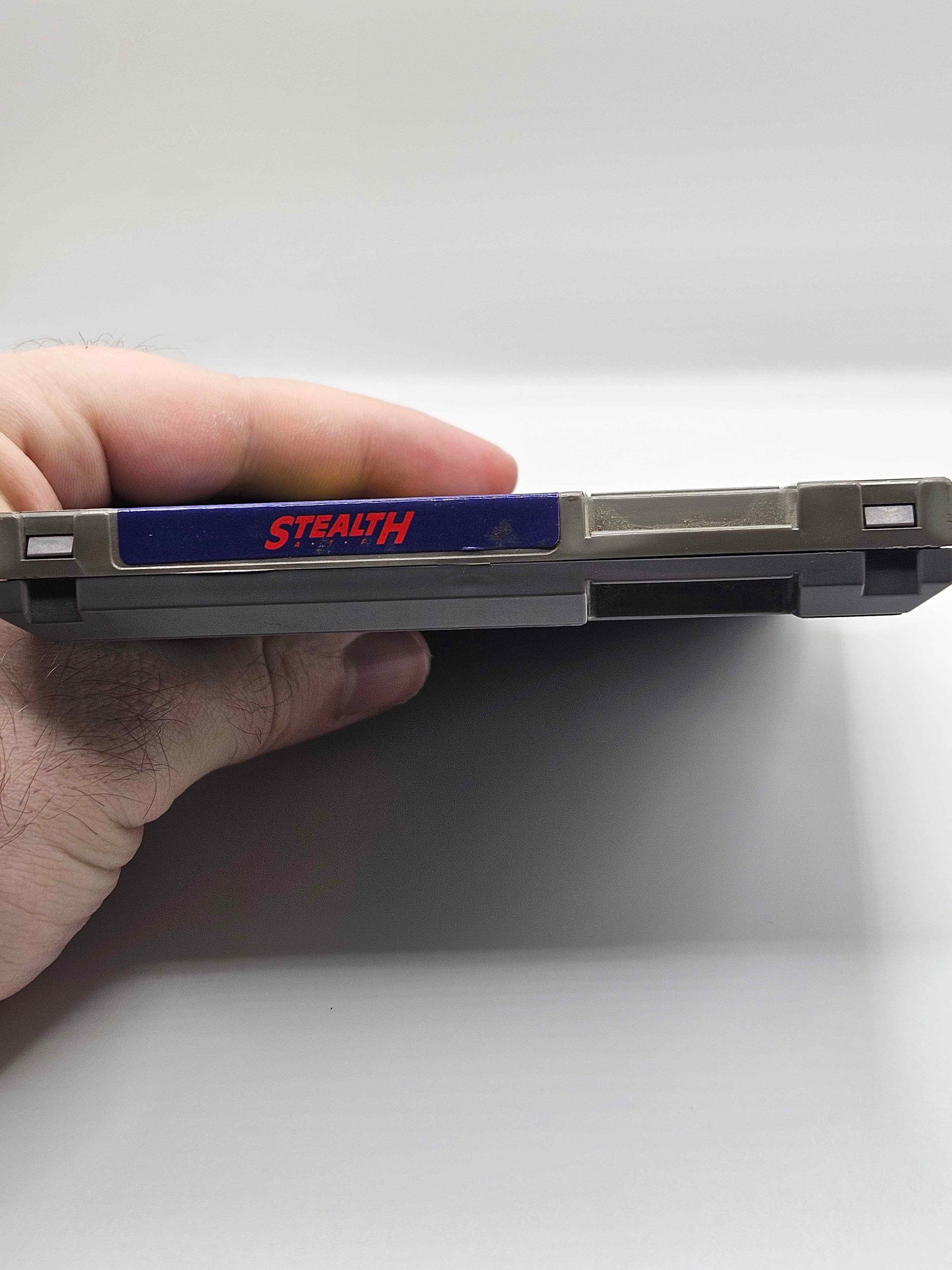 A Nintendo Entertainment System (NES) cartridge for the game 'Stealth' (top).